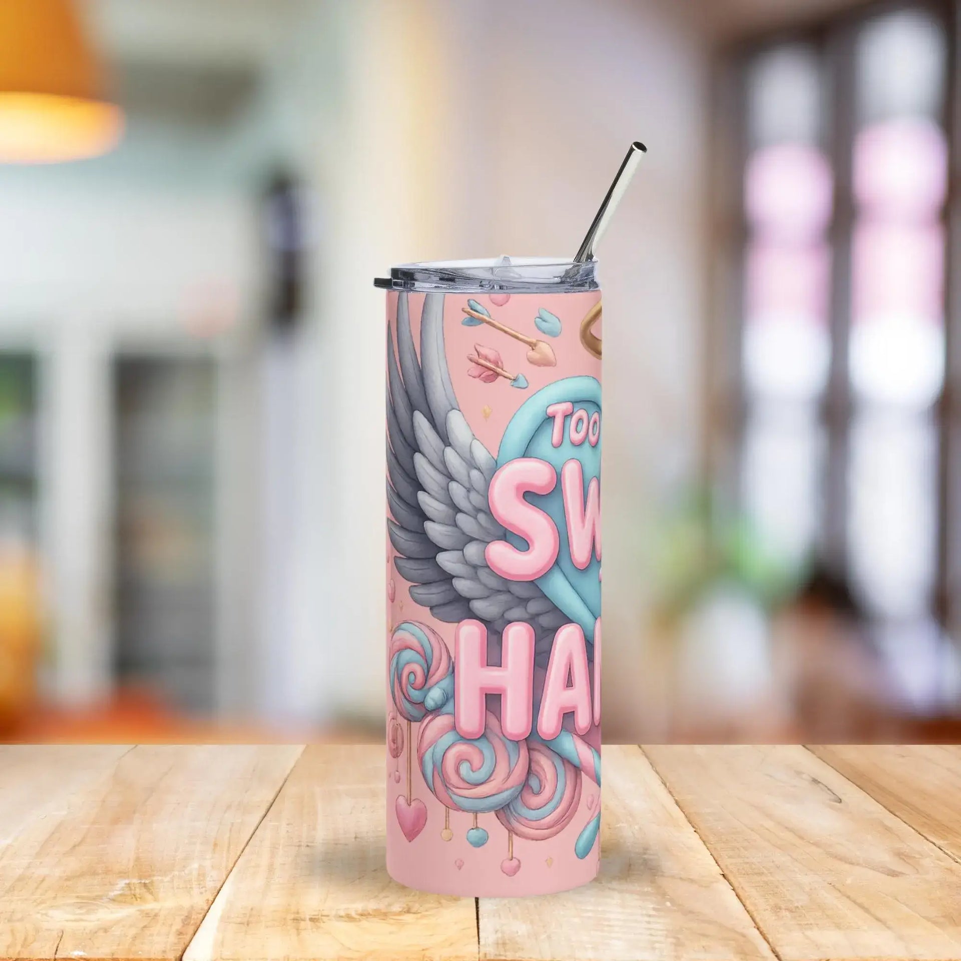 Pink tumbler with colorful design on a wooden table