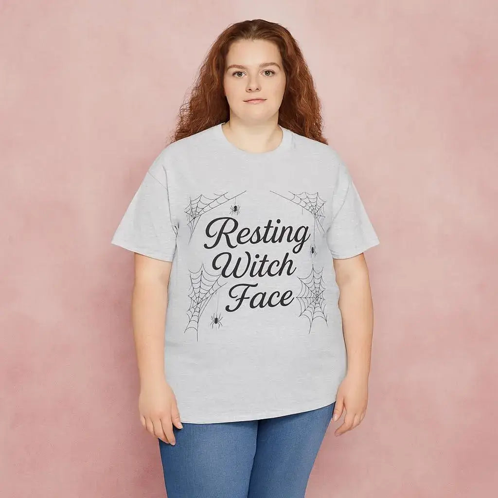 Person wearing a light gray t-shirt with 'Resting Witch Face' text and spider web design on a pink background