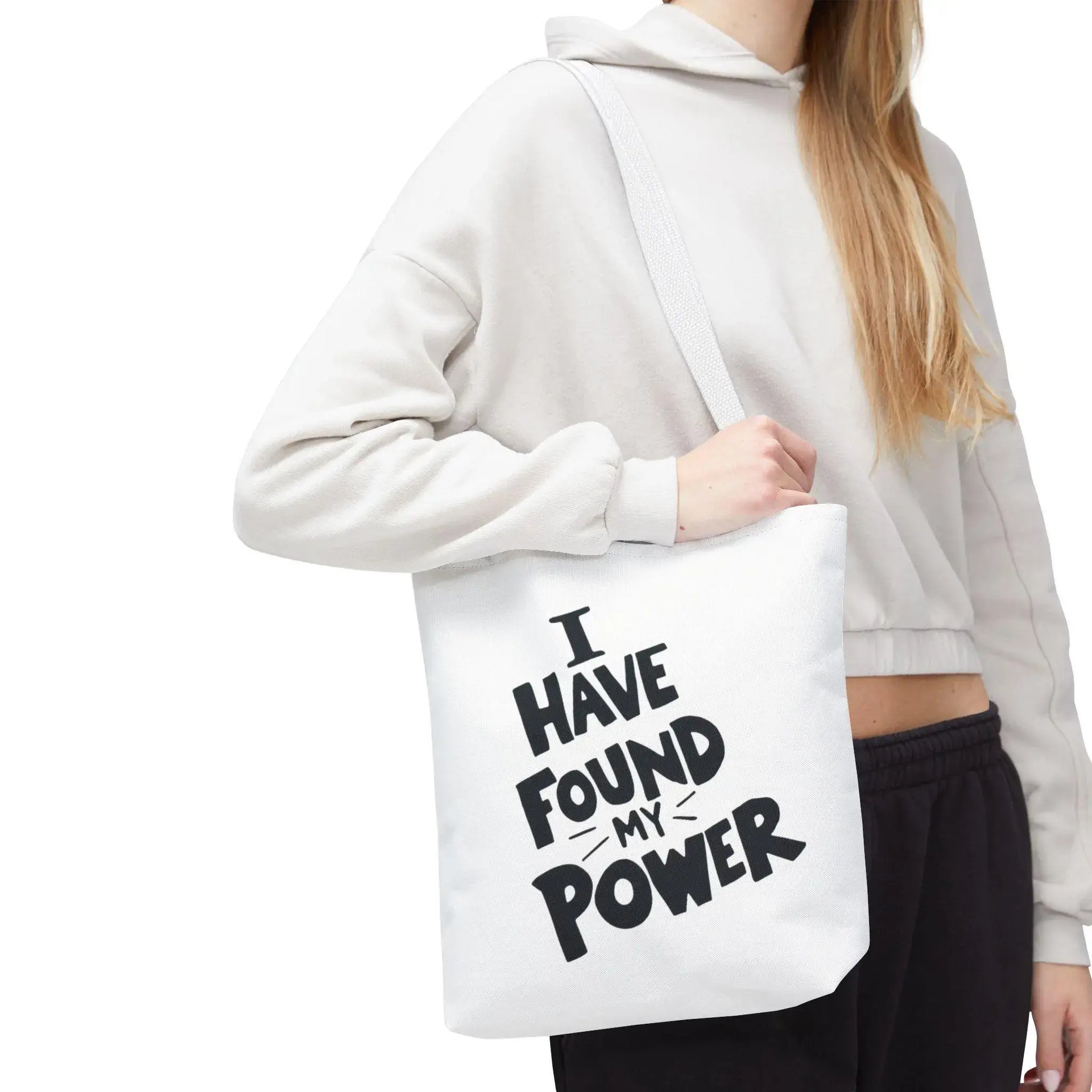 Person holding a white tote bag with 'I HAVE FOUND MY POWER' text.