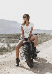 Woman sitting on a motorcycle in a desert setting