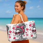 Woman holding a beach bag with skull and heart design on a beach