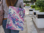 Person holding a colorful tote bag with animal designs outdoors.