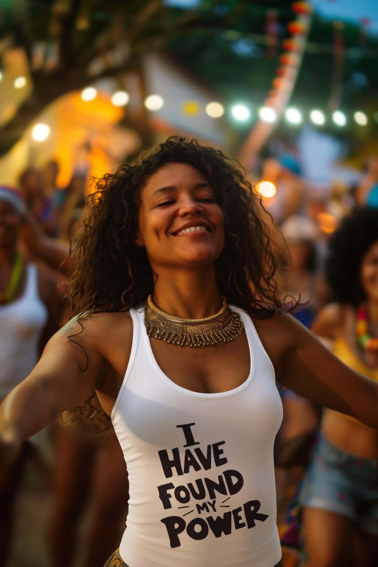 Woman in a white tank top with 'I Have Found My Power' text, surrounded by people at a festive event.