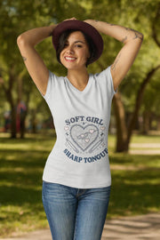 Woman wearing a white t-shirt with 'Soft Girl Sharp Tongue' design in a park.