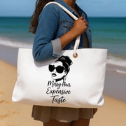 Person holding a tote bag with a design and text on a beach