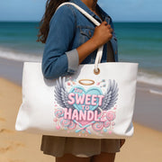 Person holding a tote bag with a design on a beach