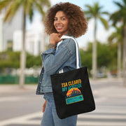 Woman holding a black tote bag with 'TSA Cleared My Altitude' design on a city street.
