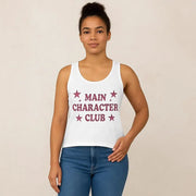 Person wearing a white tank top with 'MAIN CHARACTER CLUB' text and stars on a beige background