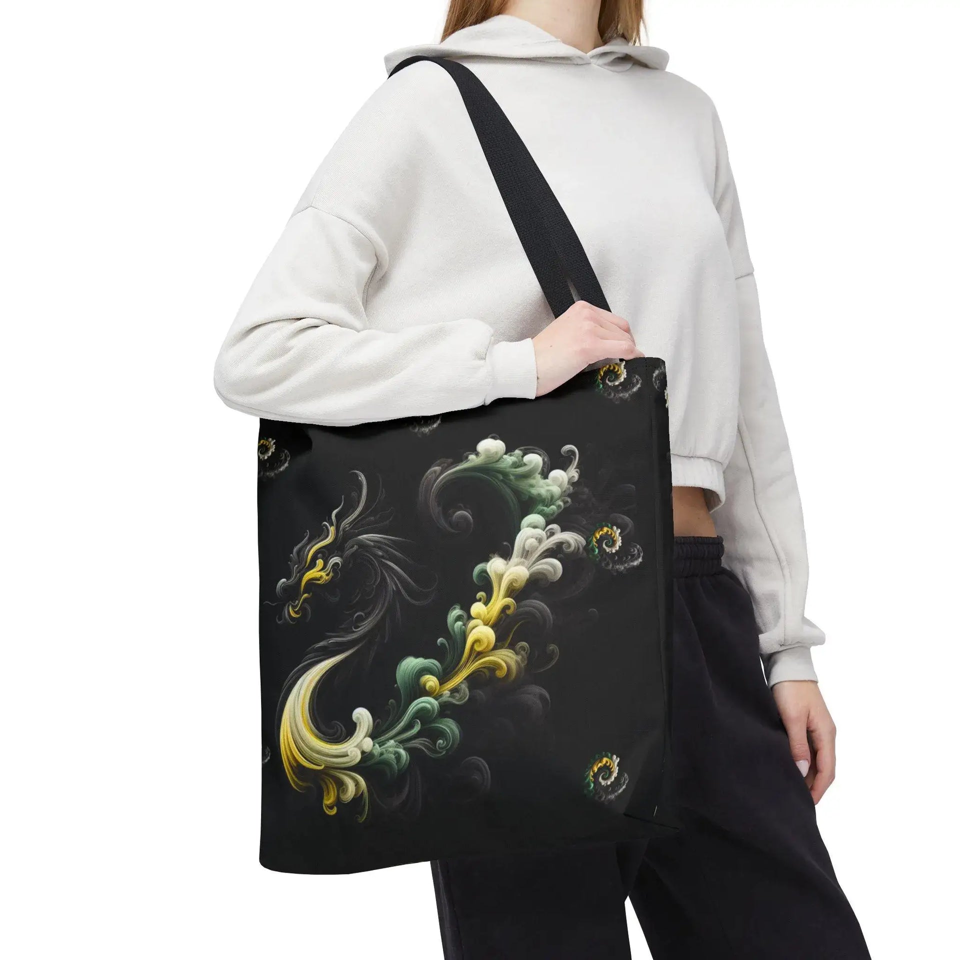 Person wearing a white hoodie and black pants, carrying a black tote bag with colorful abstract designs.
