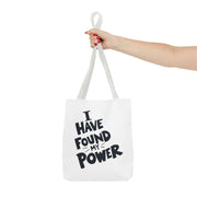 White tote bag with 'I Have Found My Power' text held by a hand on a white background
