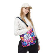 Person holding a colorful bag with floral design and text on a white background