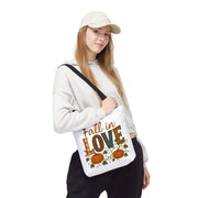 Person holding a tote bag with 'Fall in Love' text and pumpkins on a white background