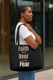 Woman carrying a black tote bag with motivational text, standing outdoors.