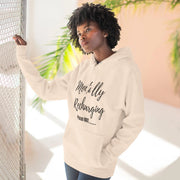 Person wearing a beige hoodie with text, standing against a light background with plants.