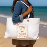 Person holding a white tote bag with a quote on a beach