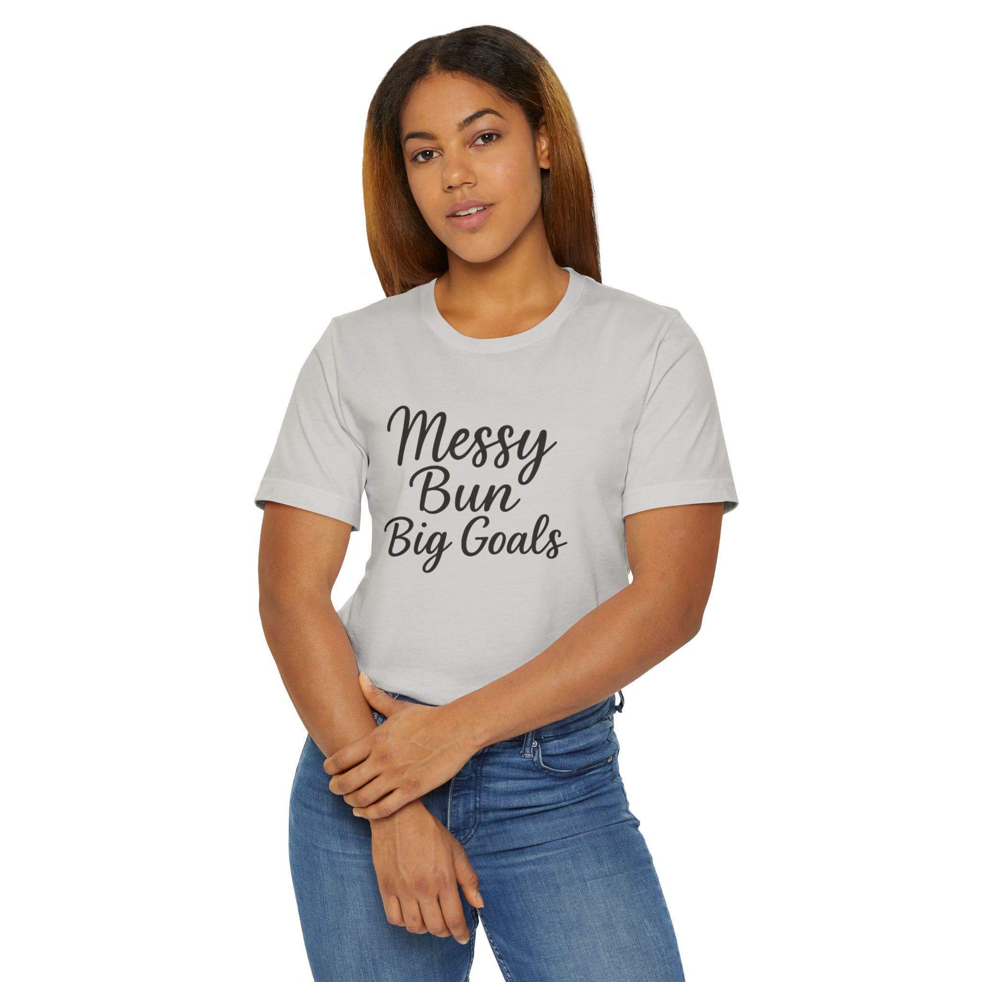 Woman wearing a gray t-shirt with 'Messy Bun Big Goals' text on a white background