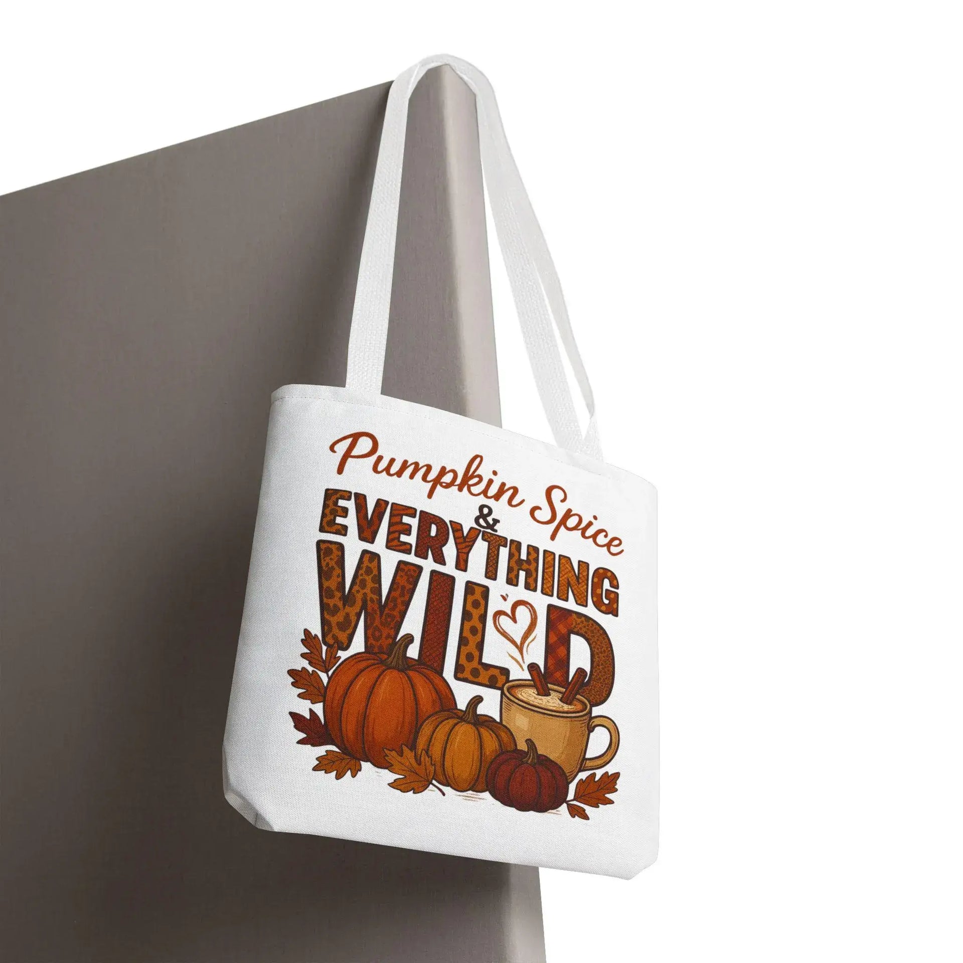 Tote bag with 'Pumpkin Spice & Everything Wild' text and autumn-themed graphics on a white background.