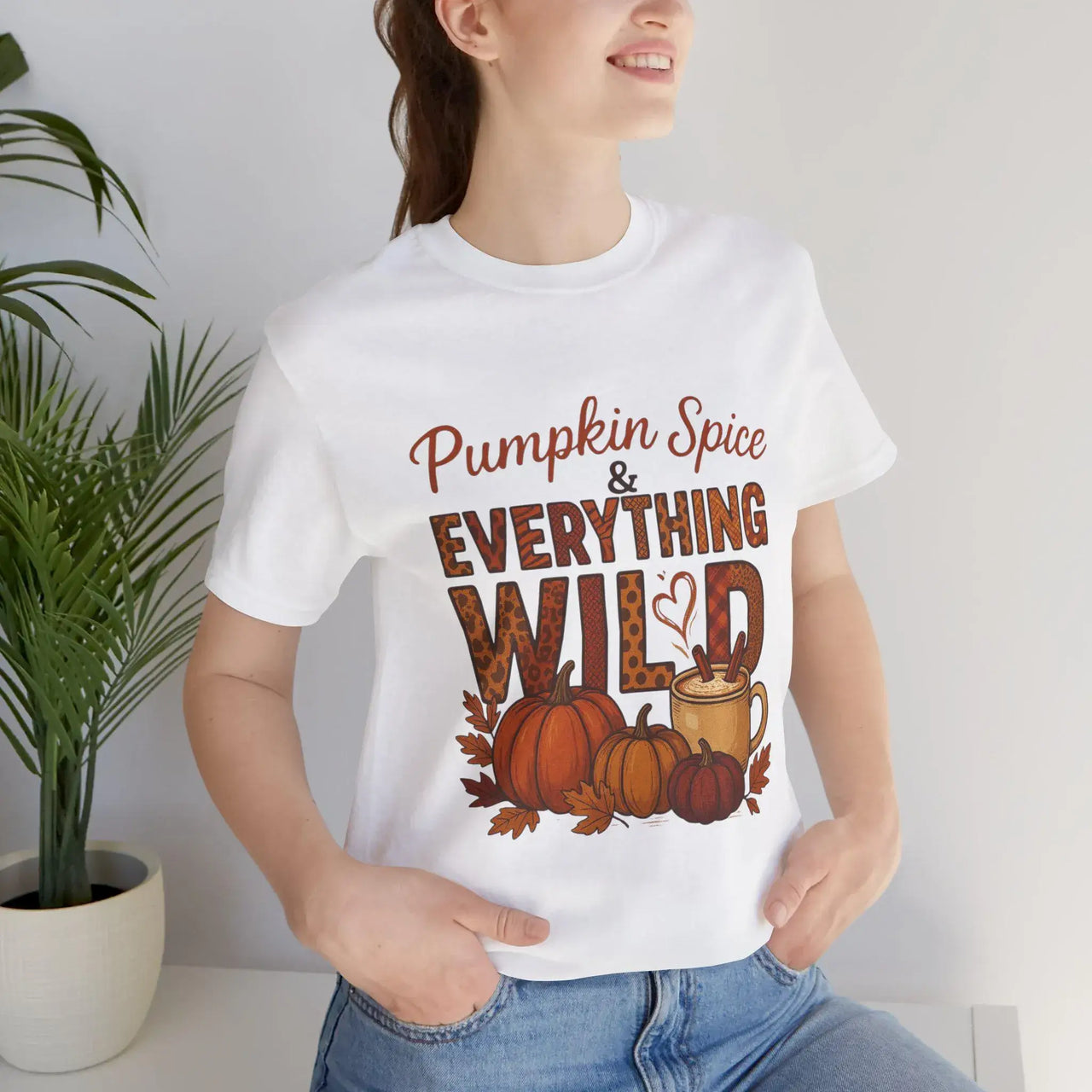 Person wearing a white t-shirt with 'Pumpkin Spice & Everything Wild' text and graphics.