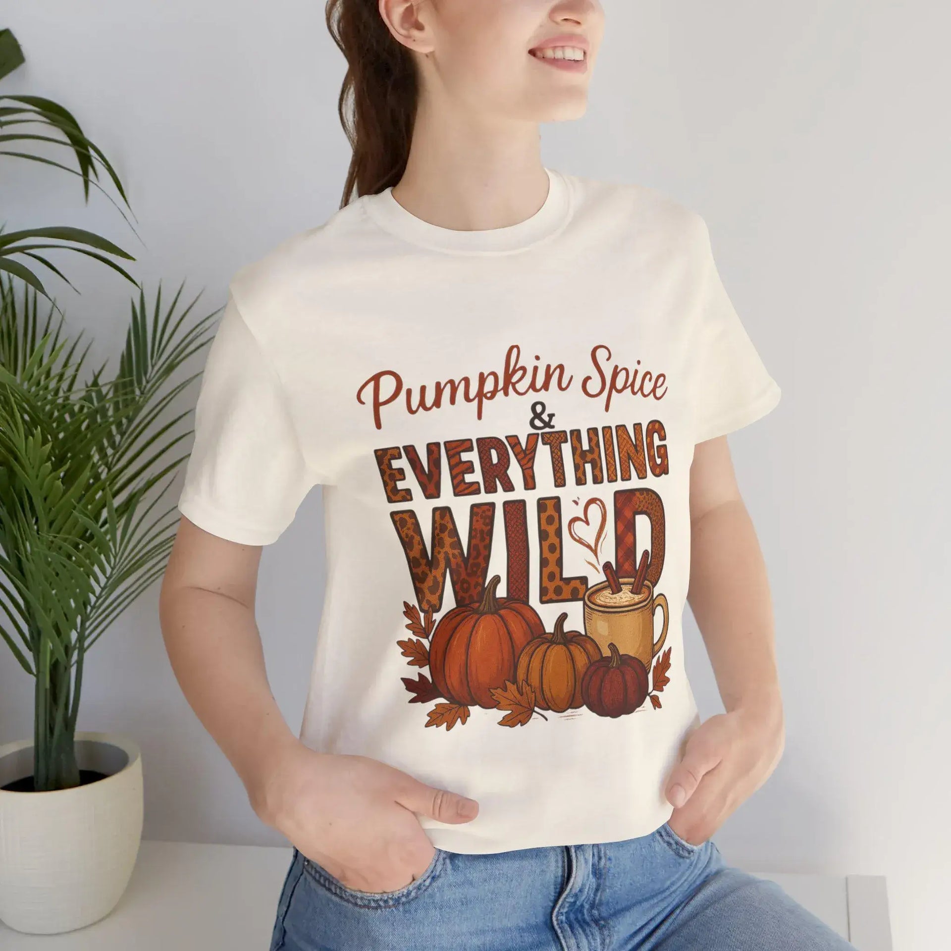 Person wearing a white t-shirt with 'Pumpkin Spice & Everything Wild' design.