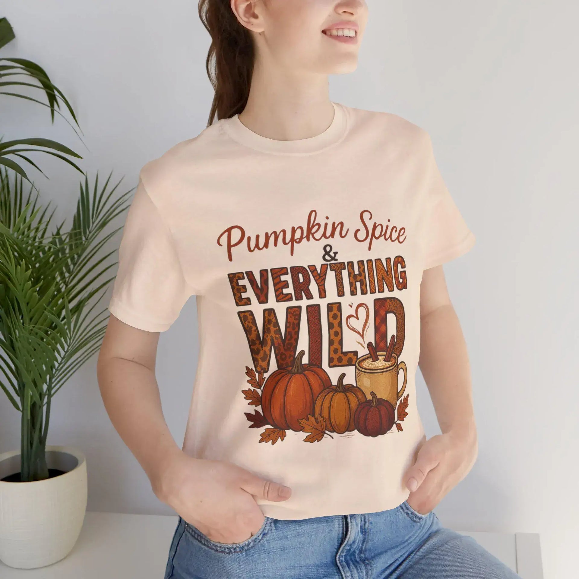 Person wearing a t-shirt with 'Pumpkin Spice & Everything Wild' design.