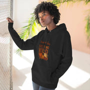 Person wearing a black hoodie with a graphic design, standing indoors with plants in the background.
