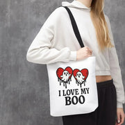 Person holding a tote bag with ghost and heart design and text 'I Love My Boo' against a gray background