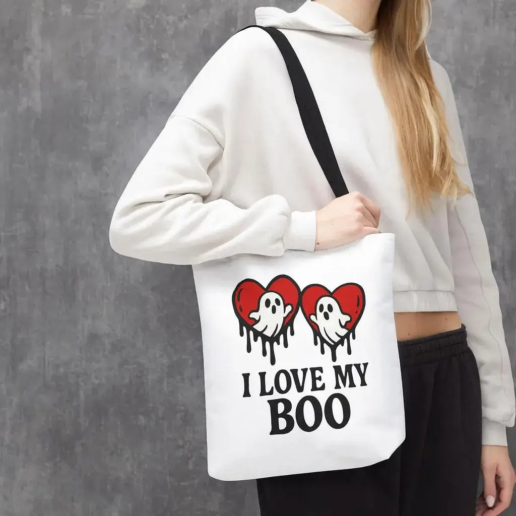 Person holding a tote bag with ghost and heart design and text 'I Love My Boo' against a gray background