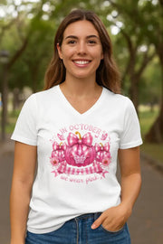 Woman wearing a white t-shirt with a pink graphic design outdoors.